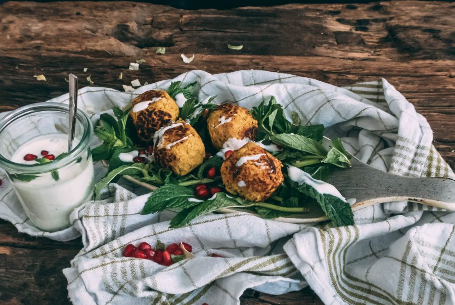 Falafel auf einem Bett aus Minze und Granatapfel, beträufelt mit einem Dip aus Joghurt und Minze
