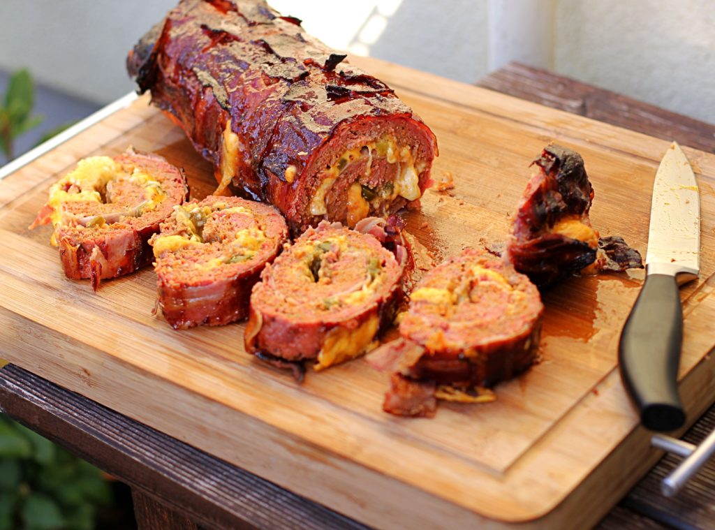 Auf einem Holzbrett liegt die Chili Cheese Bacon Bomb von Grill_Daddy.