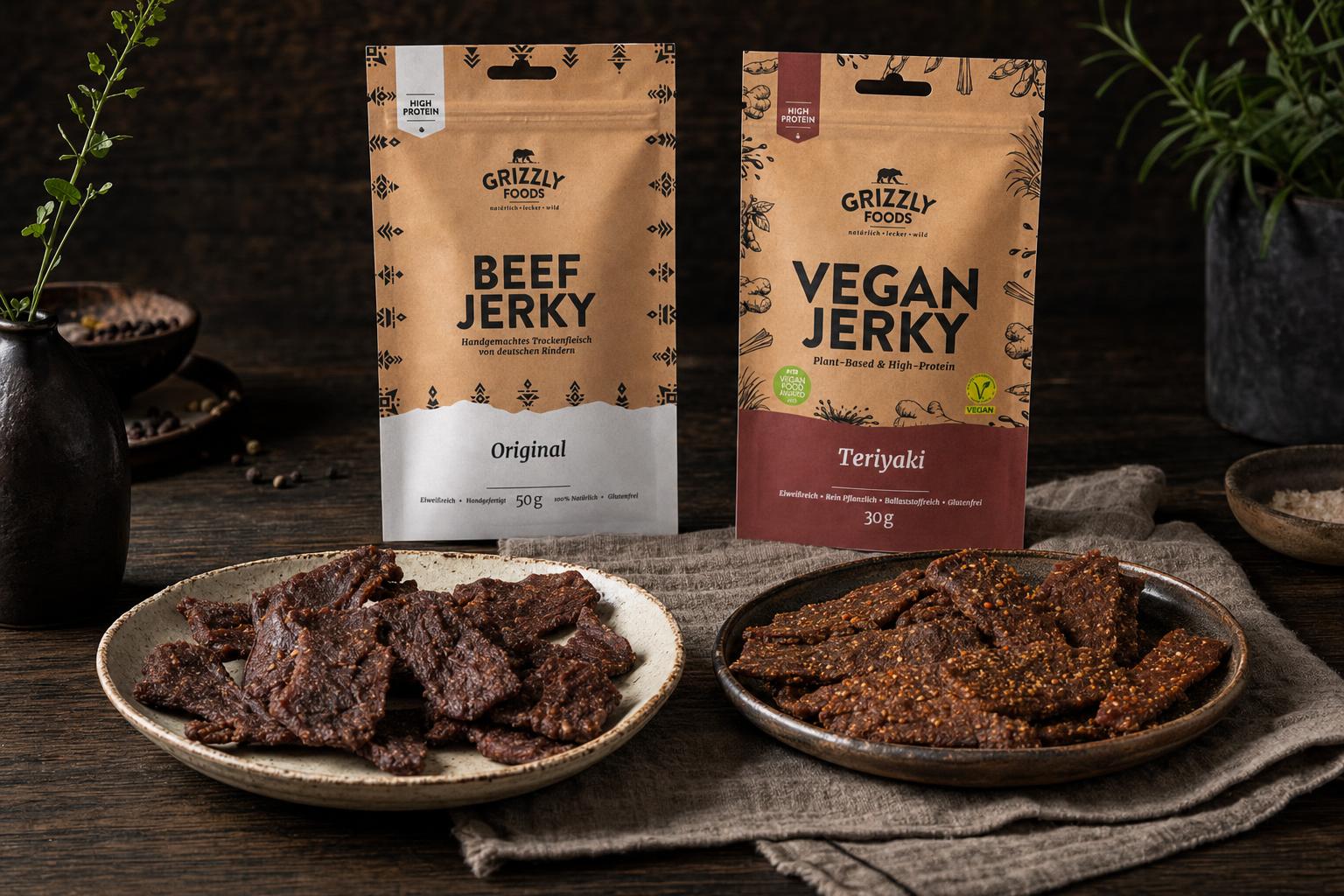 Dünne Streifen Beef Jerky und veganes Jerky nebeneinander auf dunklem Untergrund, jeweils mit passender Snack-Verpackung im Hintergrund.