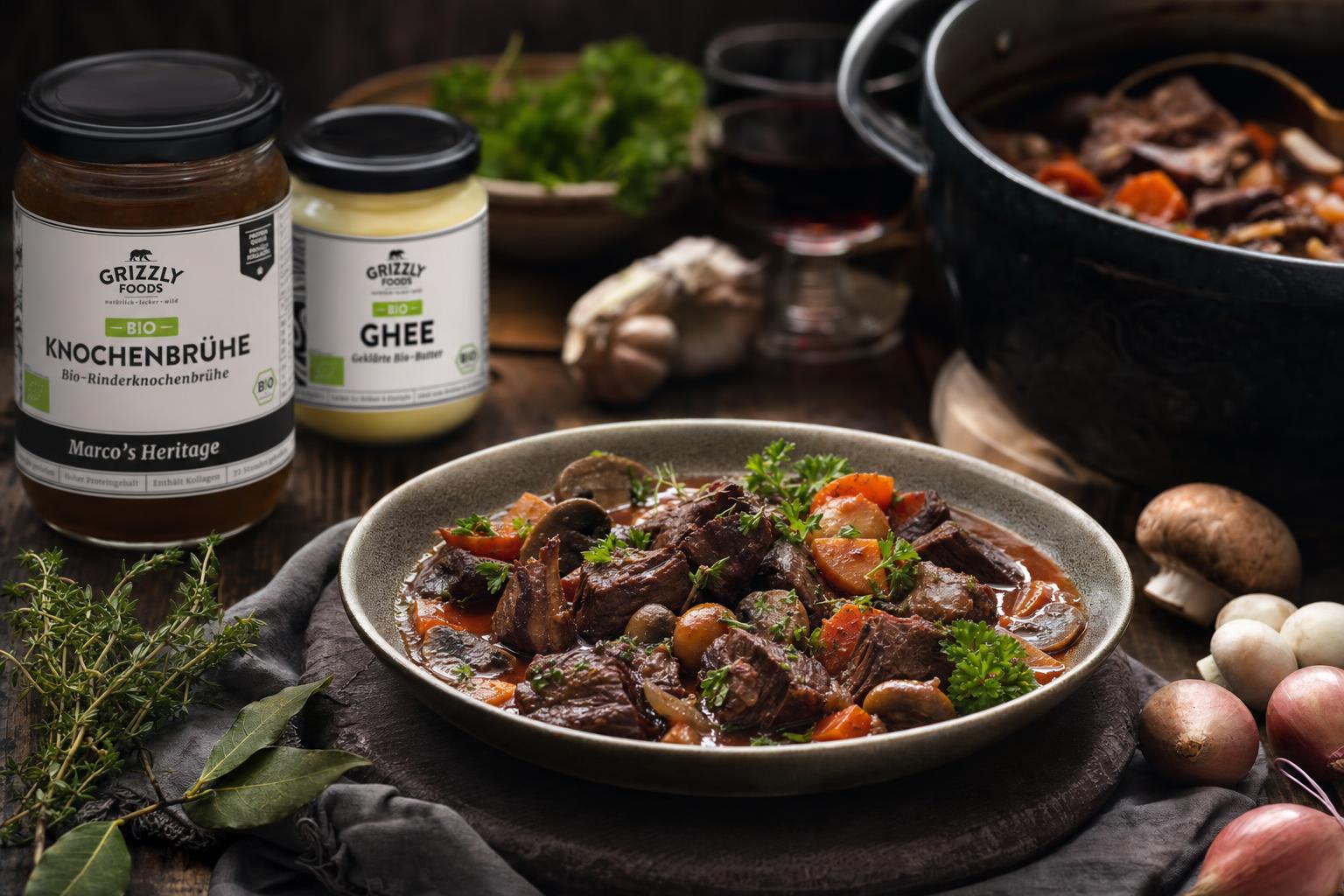 Boeuf Bourguignon mit Rindfleischwürfeln, Möhren, Schalotten, Champignons und Speck in dunkler Sauce auf einem Teller angerichtet