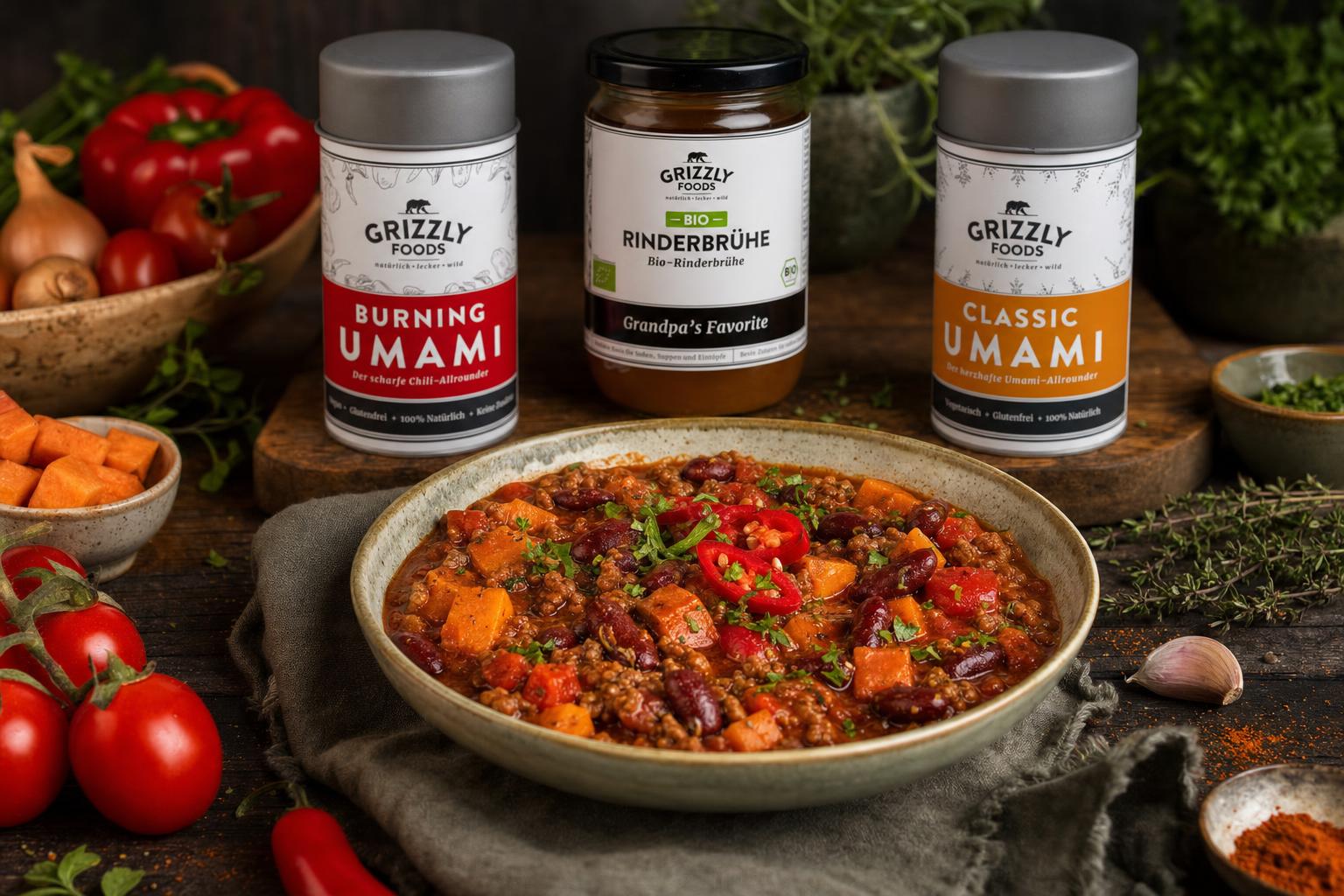 Teller mit Chili con Carne, darin Hackfleisch, Kidneybohnen, Tomaten, Paprika und Süßkartoffel, garniert mit frischer Chili
