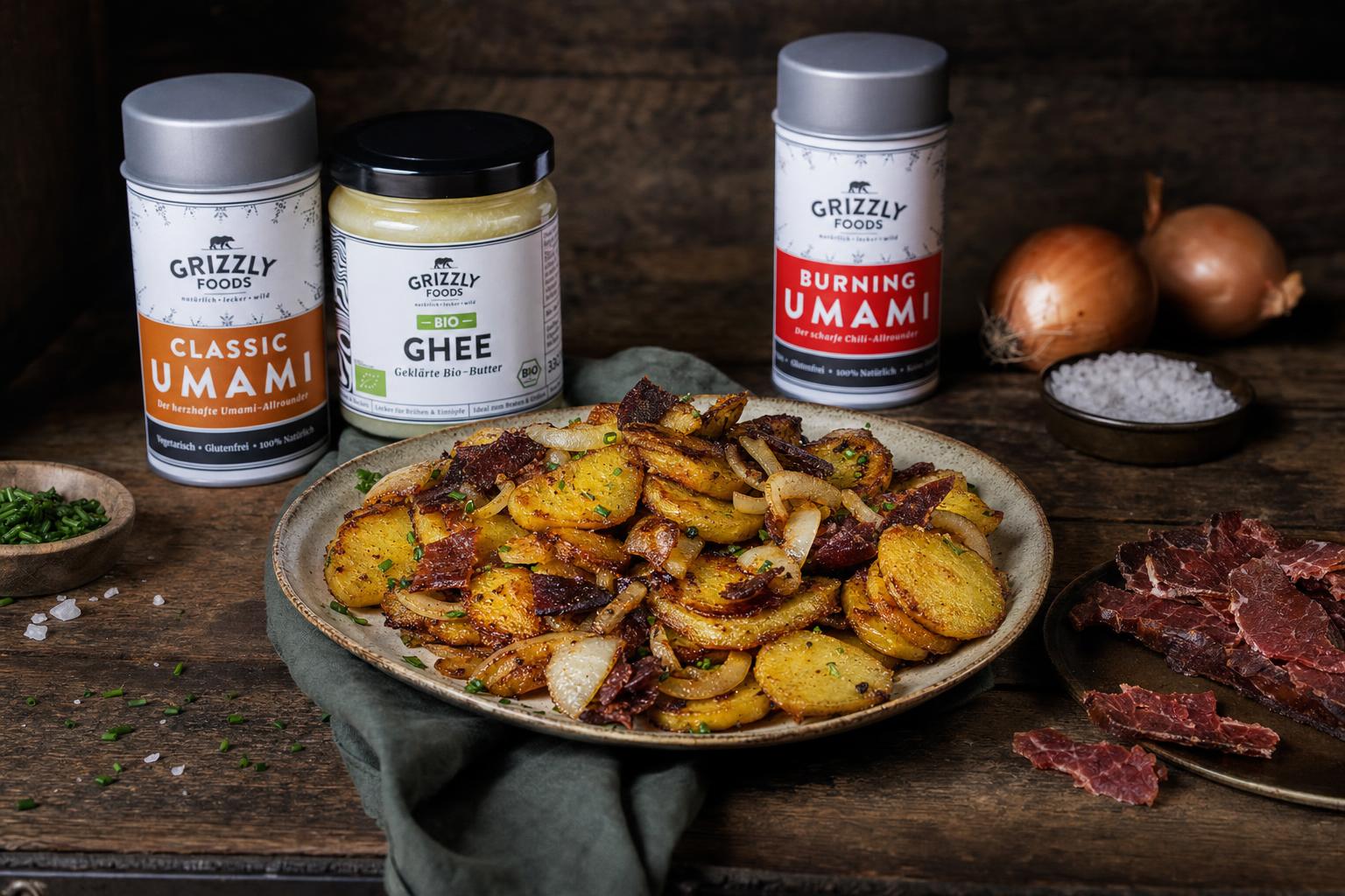 Knusprig gebratene Kartoffelscheiben mit Zwiebeln und Beef Jerky auf einem Teller, goldbraun und appetitlich angerichtet.