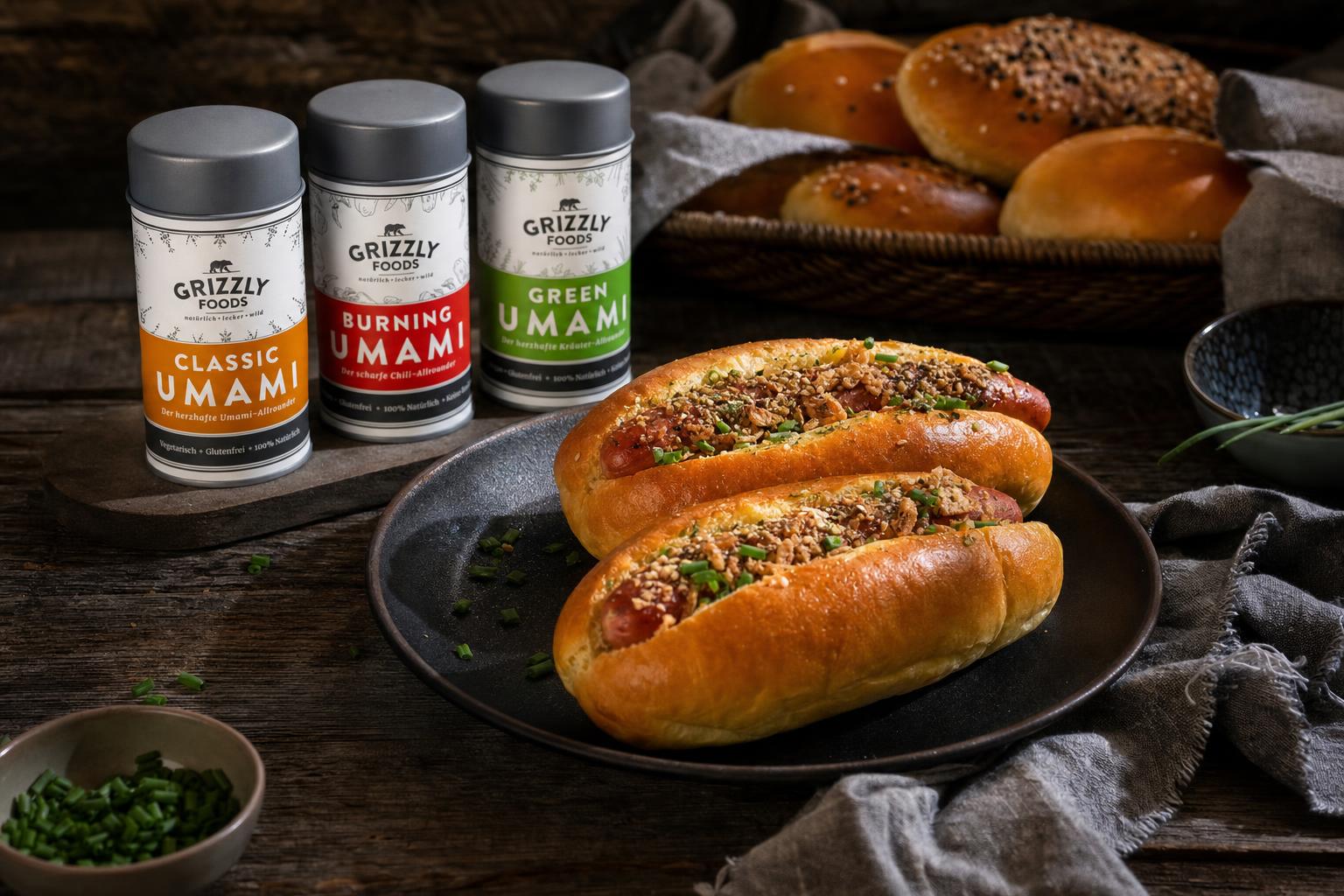 Sechs goldbraune, längliche Hot Dog Brötchen liegen nebeneinander auf einem Backblech.