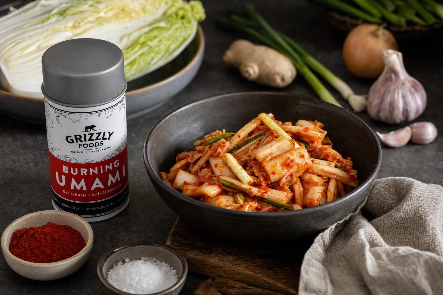 Schüssel mit fermentiertem Kimchi aus Chinakohl, Frühlingszwiebeln und Gewürzen, garniert mit roten Chiliflocken.