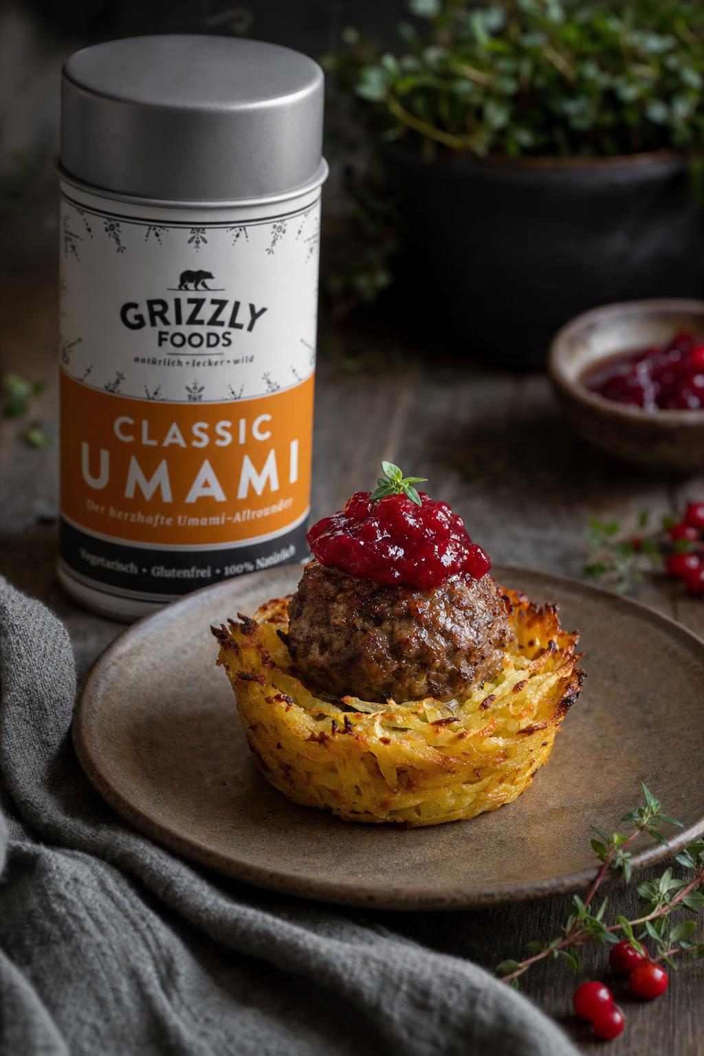 Köttbullar-Muffin mit Fleischbällchen obenauf, daneben Preiselbeeren und etwas braune Sauce auf einem Teller angerichtet