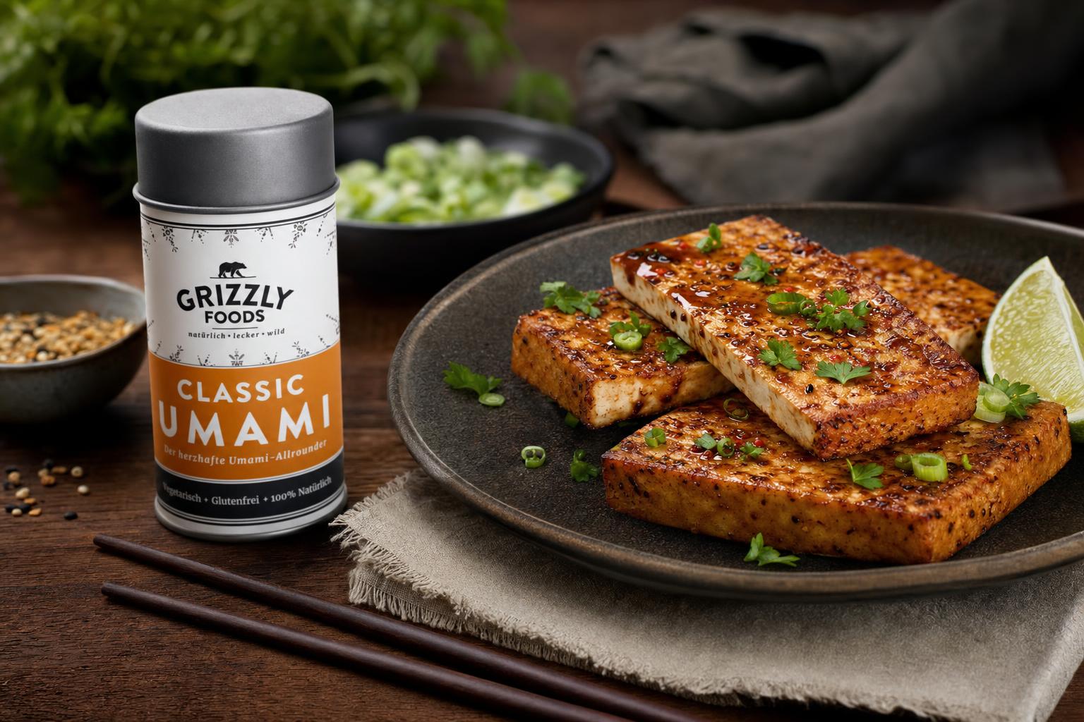 Drei dicke, rechteckige Stücke glasiertes, gegrilltes Tofu mit Petersilie auf schwarzem Teller, serviert auf Holztisch.