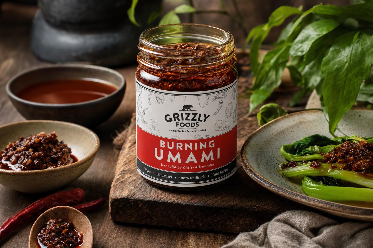 Ein Glas mit dunkelroter, stückiger XO-Sauce steht auf Holz, im Hintergrund grüne Blätter, die Sauce wirkt aromatisch und frisch.